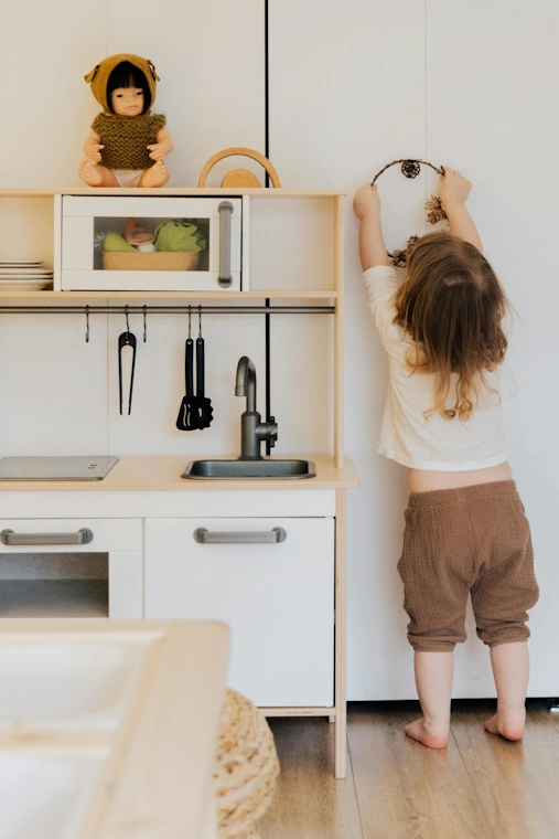 toddler reaching for hanging item
