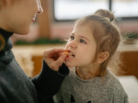 child eating strawberry